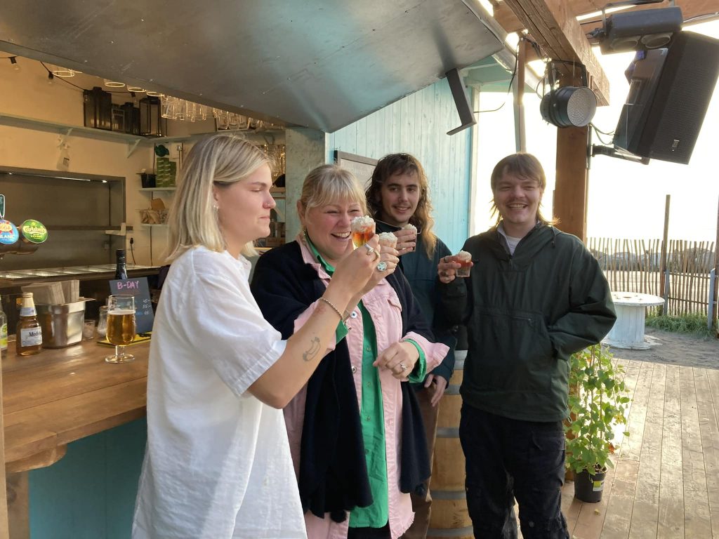 Karin drinking cake shots with Debbie, Martin, and Theo